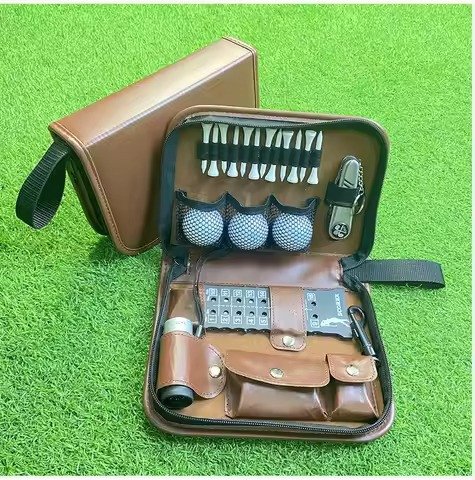Leather tool case set with balls, tees and brushes on turf