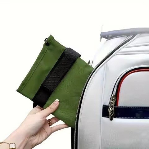 Green valuables pouch strapped to a bag handle
